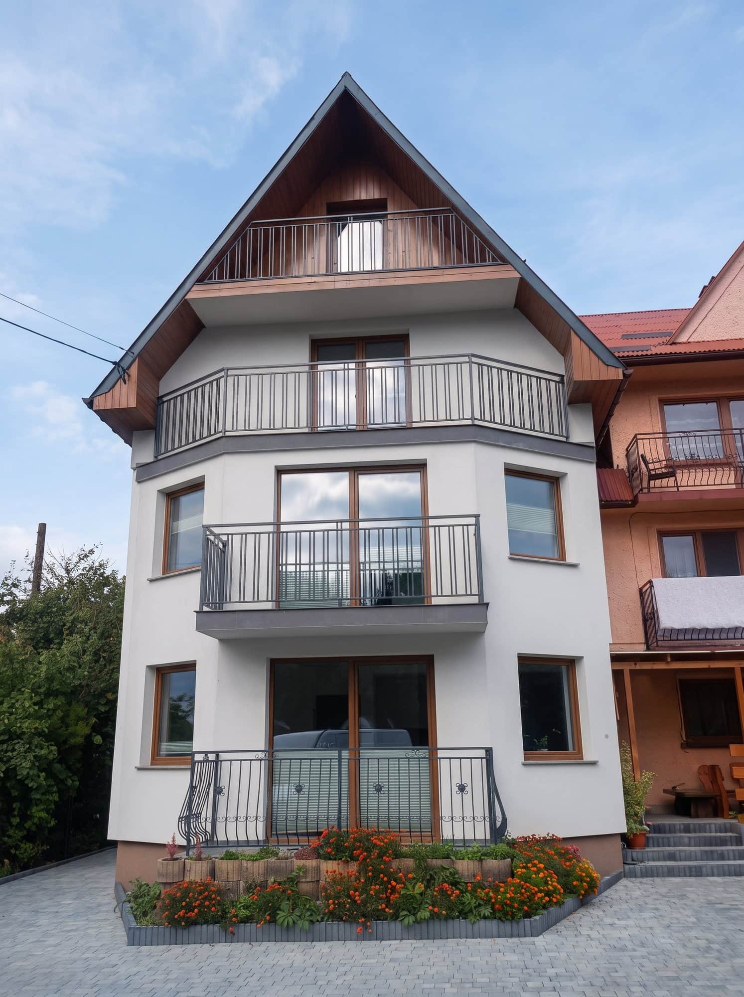 Dom jednorodzinny z czarnymi balustradami na balkonach