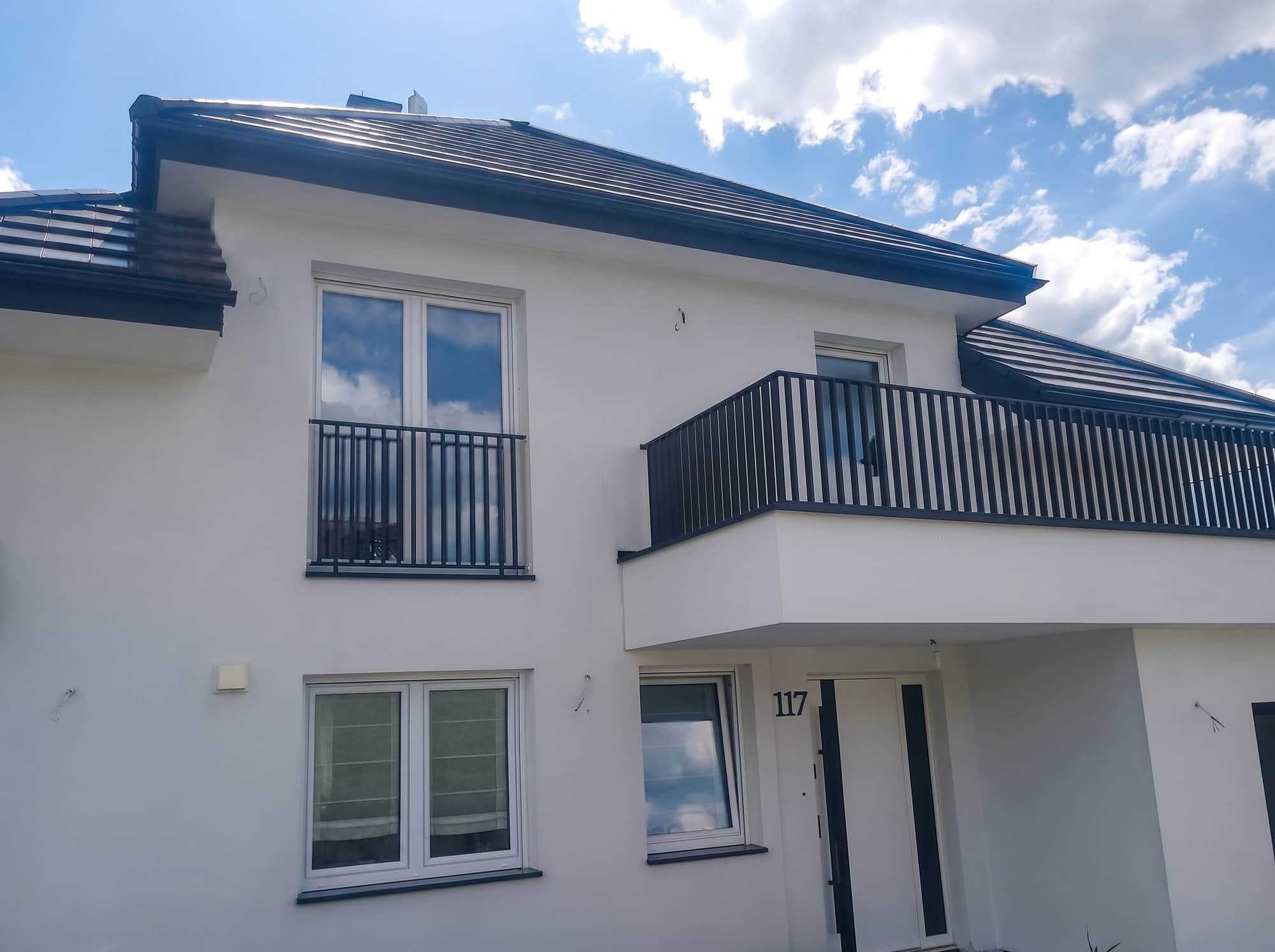 Elewacja domu z balustradami balkonowymi z pionowych prętów